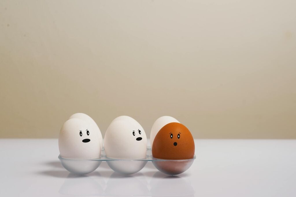 représentation de 6 oeufs - cinq sont blancs et le sixième est de couleur beige - pour illustrer la discrimination, une des causes de travail toxique