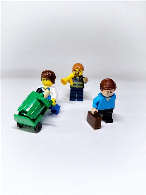 Illustration Lego représentant un manager toxique avec un haut-parleur, tandis que deux collègues contrariés s’éloignent, illustrant les signes d’un manager toxique et leur impact sur l’équipe.