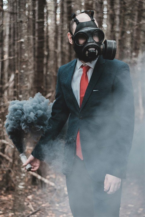 Manager toxique créant un climat de peur et de stress au travail, illustré par un homme en costume avec un masque à gaz et un fumigène.
