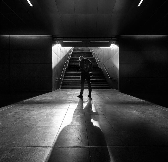 Personne montant des escaliers lumineux, illustrant une carrière qui avance même lorsqu’on croit être en retard.
