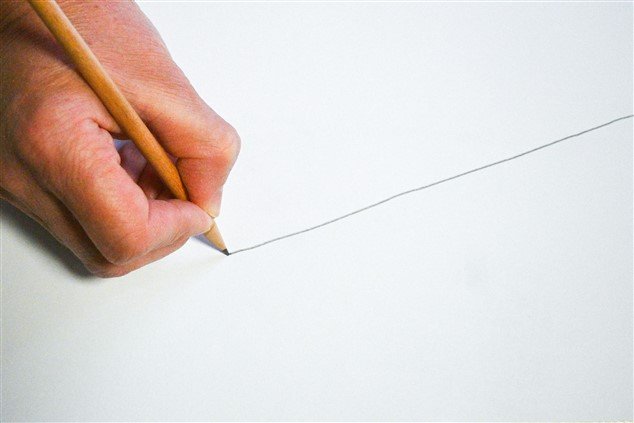 Main traçant un trait au crayon à papier sur une feuille pour symboliser la limite à mettre devant un collègue faux gentil manipulateur