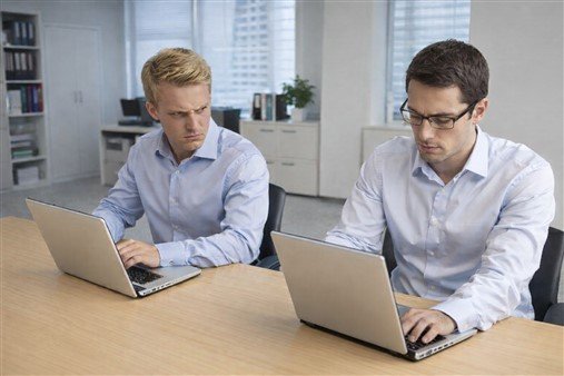 Collègue jaloux qui ressent un sentiment de rivalité et regarde son collègue d'un air mauvais.